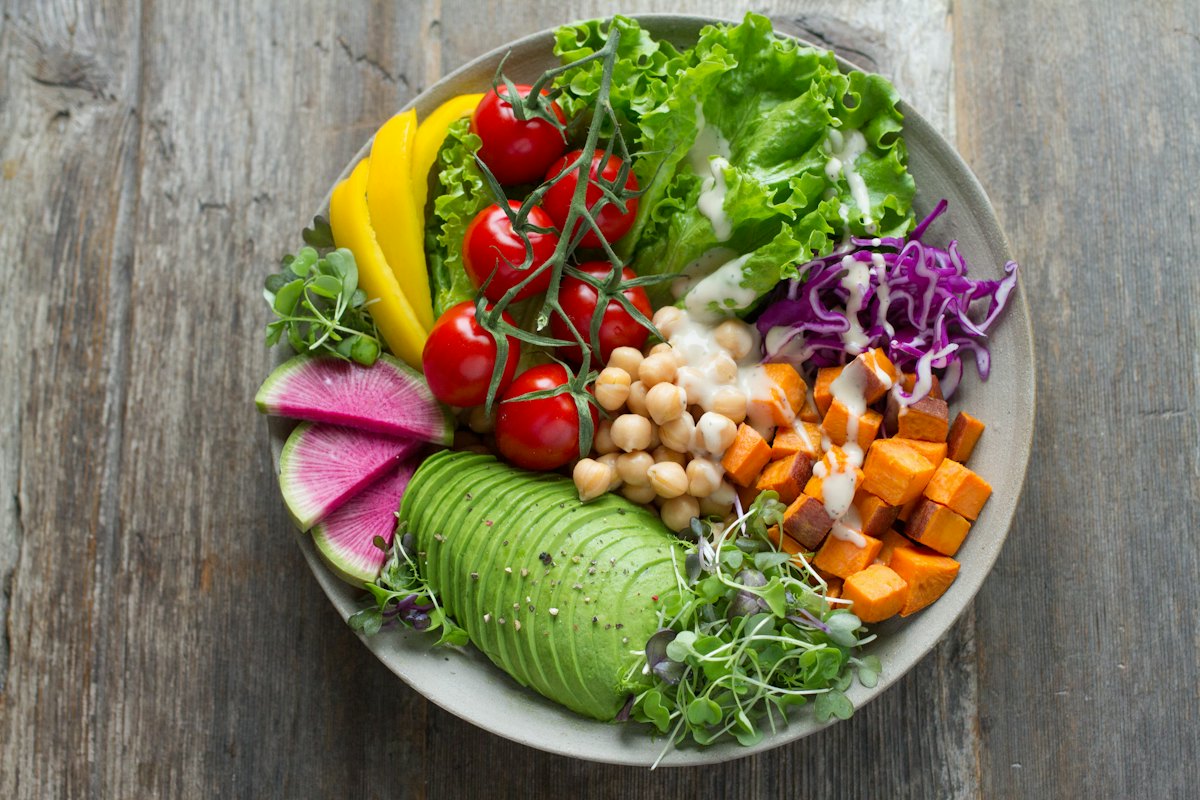 A bowl of chickpeas, avocado, tomatoes and greens